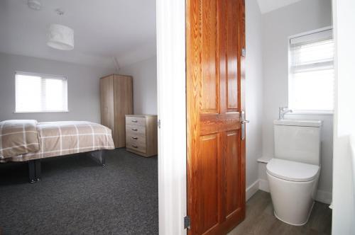 a bathroom with a toilet and a bedroom with a bed at Cohost Partners, Monthly/Weekly discounts in Bristol