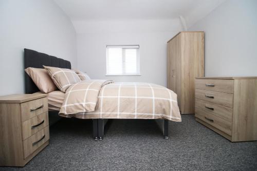 ein Schlafzimmer mit einer Kommode und einem Bett sidx sidx sidx sidx sidx in der Unterkunft Cohost Partners, Monthly/Weekly discounts in Bristol