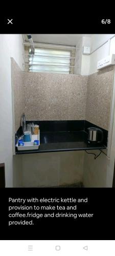 um balcão de cozinha com um lavatório e uma janela em PADMA em Visakhapatnam