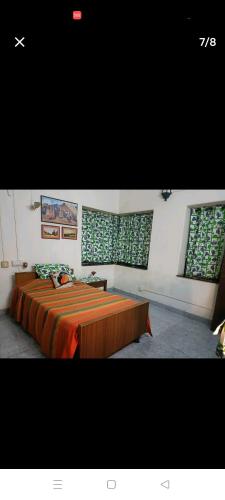 um quarto com uma cama grande e 2 janelas em PADMA em Visakhapatnam