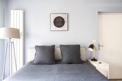 1 dormitorio con 1 cama y reloj en la pared en Le Petit Rocher, en Vienne