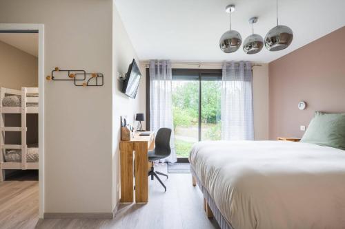 1 dormitorio con cama, escritorio y ventana en Le Petit Rocher, en Vienne