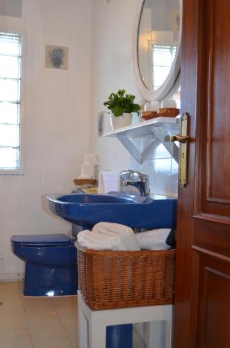 a bathroom with a blue sink and a toilet at Casa Aurora in Teo