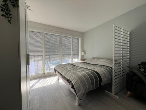 a bedroom with a bed and a large window at Logement entier : appartement proche de Paris ⸱ Chez Geoffrey in Châtillon