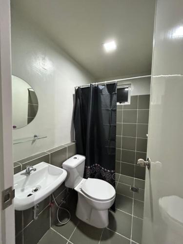 a bathroom with a toilet and a sink and a shower at BRIA FLATS LAS PINAS in Manila