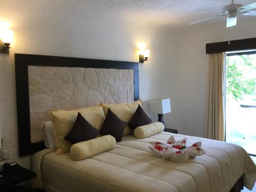 a bedroom with a large bed with two bowls on it at Hotel Club Akumal Caribe in Akumal