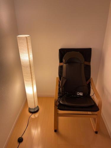 una lampada seduta accanto a una sedia accanto a un lampione di 孔雀民宿 ad Osaka