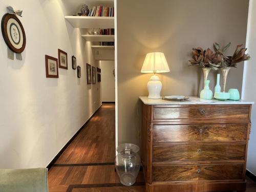 a room with a dresser with a lamp and a hallway at Villa Liberty TownHouse in Siena