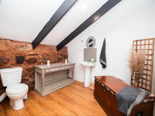 un baño con inodoro y lavabo en Crooked Cottage, en Pelindaba
