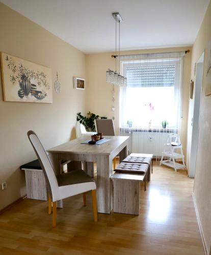 a dining room with a table and chairs and a window at Angela Apartments in Würzburg