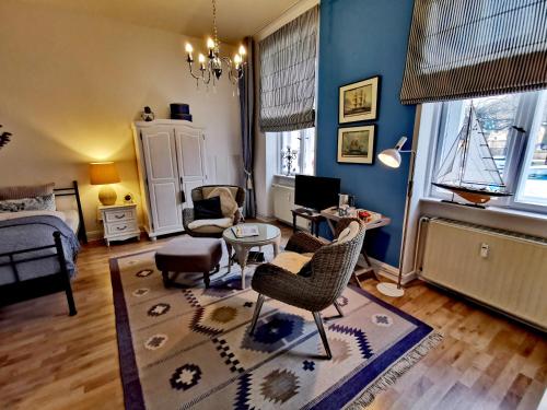 uma sala de estar com paredes azuis e um sofá e cadeiras em Bed&Breakfast Wagner "im Alten Pfarrhaus" em Neuruppin