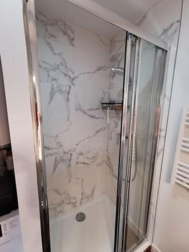 une salle de bain avec une douche avec une porte vitrée dans l'établissement Charbon studio climatisé parking terrasse, à Villeneuve-lès-Avignon
