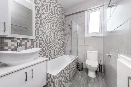 a white bathroom with a sink and a toilet at Green Bay Villa #15 in Protaras