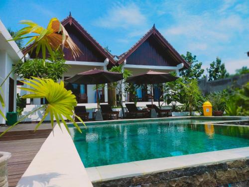 a villa with a swimming pool and a house at The Local Are Guling in Kuta Lombok