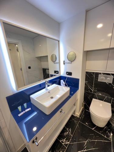 巴統的住宿－Orbi City Batumi，一间带水槽、卫生间和镜子的浴室