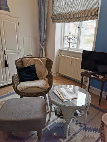 a living room with a chair and a table and a piano at Bed&Breakfast Wagner "im Alten Pfarrhaus" in Neuruppin