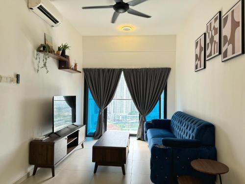 a living room with a blue couch and a tv at Reizz Residence By Nexus Suites in Kuala Lumpur
