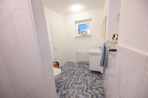 ein Bad mit einem WC und einem Waschbecken in der Unterkunft Ferienwohnung Rotbuche, 25517 in Weener