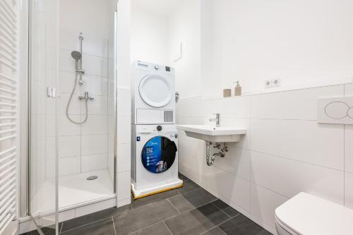 uma casa de banho com uma máquina de lavar roupa e um lavatório em Schiller Apartment Neukölln em Berlim