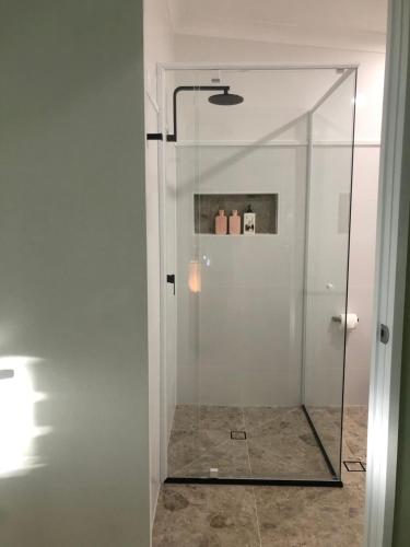 um chuveiro com uma porta de vidro na casa de banho em Tamborine Mountain Lodge em Mount Tamborine