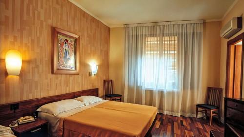 a hotel room with a bed and a window at Hotel Nazionale in Bolsena