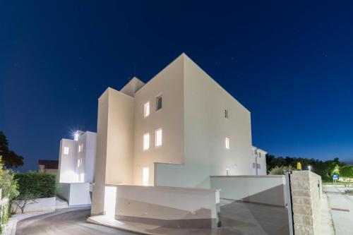 een wit gebouw wordt 's nachts verlicht bij A&V Residence in Novigrad Istria