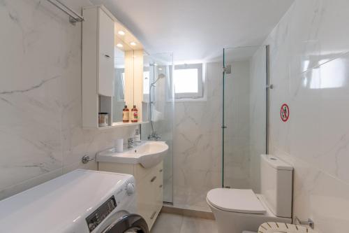 a bathroom with a toilet and a sink and a shower at Alimos Marina Sunnyhub in Athens