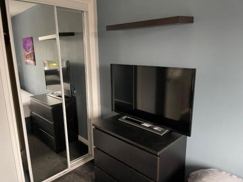 a living room with a television and a mirror at Kilmarnock in Kilmarnock