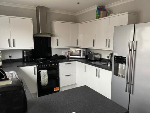 a kitchen with white cabinets and a black stove at Kilmarnock in Kilmarnock