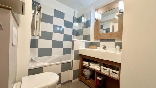 une salle de bain avec un lavabo, des toilettes et un miroir dans l'établissement Chez Nannou et Chris, à Fort-Mahon-Plage