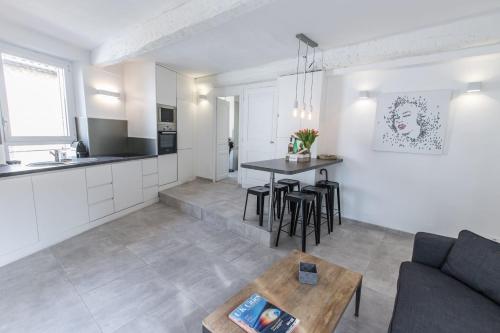 un salon et une cuisine avec un canapé et une table dans l'établissement 2 pièces balcon 4 pers Meynadier Palais 1 minute by Olam Properties, à Cannes