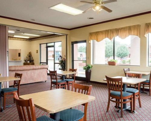 a dining room with tables and chairs and a couch at Rodeway Inn in Greenwood