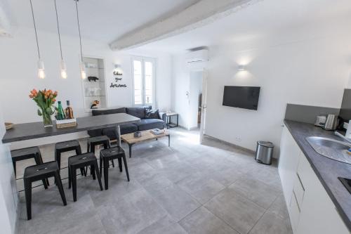 une cuisine et un salon avec une table et des chaises dans l'établissement 2 pièces balcon 4 pers Meynadier Palais 1 minute by Olam Properties, à Cannes