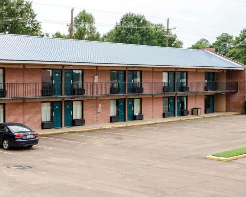 um edifício de tijolos vermelhos com um carro estacionado num parque de estacionamento em Rodeway Inn em Greenwood