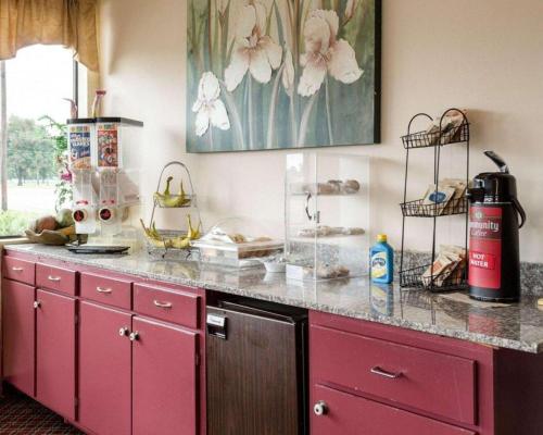 uma cozinha com armários cor-de-rosa e um balcão em Rodeway Inn em Greenwood