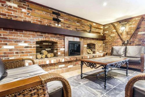 ein Backsteinzimmer mit einem Tisch und einem Kamin in der Unterkunft Comfort Inn & Suites in Collingwood