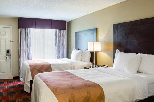 ein Hotelzimmer mit 2 Betten und einem Fenster in der Unterkunft Quality Inn in Vicksburg