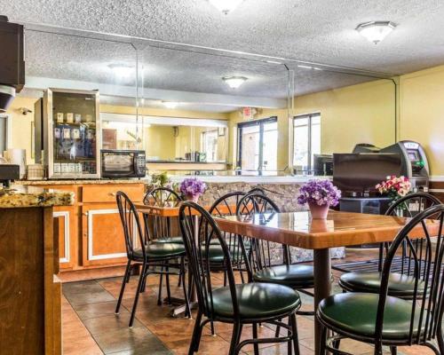 a dining room with a table and chairs and a kitchen at Econo Lodge in Glen Haven