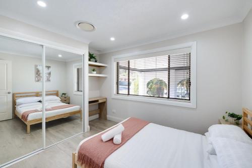 a bedroom with two beds and a window at Spacious House with Pool - 5 min walk to Lake in Wyong