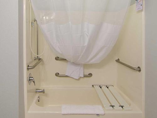 a bathroom with a bath tub with a shower curtain at Quality Inn in Seaside