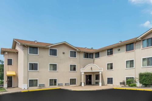 a large tan building with a courtyard at Quality Inn & Suites in Saint Louis