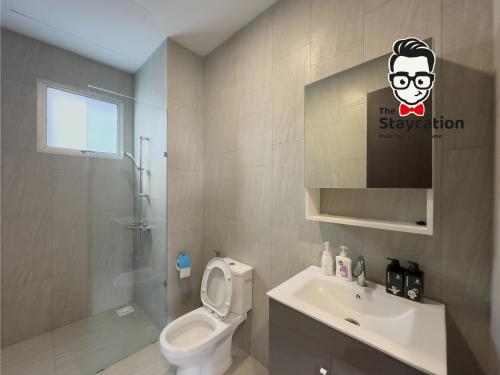 y baño con aseo blanco y lavamanos. en Staycation Homestay 41 Liberty Grove Near Airport en Kuching
