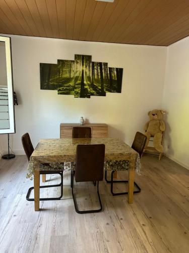 einem Esstisch mit Stühlen und einem Teddybär in der Unterkunft Ferienwohnung in Sulzbach Nähe Augenklinik in Sulzbach
