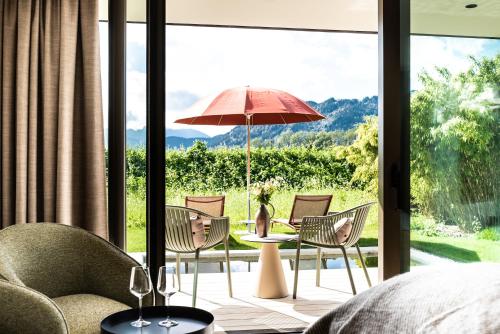 a patio with chairs and a table with an umbrella at Hotel BERGEBLICK in Bad Tölz