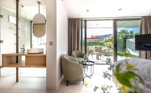 a bedroom with a bed and a desk and chairs at Hotel BERGEBLICK in Bad Tölz