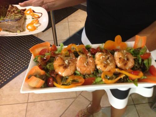 a plate of food with shrimp and vegetables on it at Montelaguna Boutique Hotel in Sámara