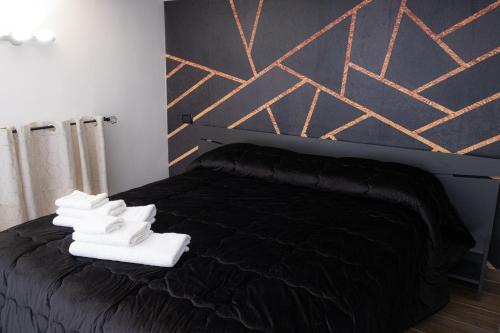Un dormitorio con una cama negra con zapatos blancos. en Napoli Center Suite Palmentieri, en Nápoles