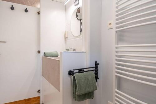 a white bathroom with a sink and a towel rack at 2 bedrooms chalet with enclosed garden and wifi at Merksplas Merksplas 