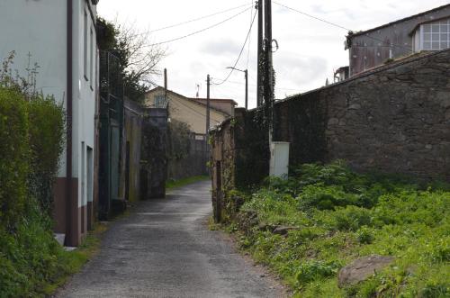 an alley with a stone wall next to a street at Casa Aurora in Teo