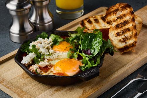 a plate of food with eggs and a salad and toast at Sky Loft Hotel Kyiv by Rixwell International in Kyiv